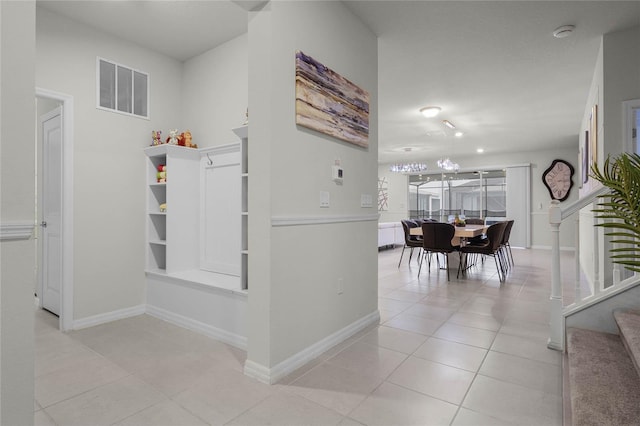 corridor featuring stairway, light tile patterned flooring, visible vents, and baseboards