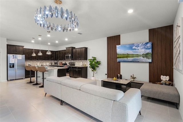 living area with light tile patterned floors, recessed lighting, visible vents, and an inviting chandelier