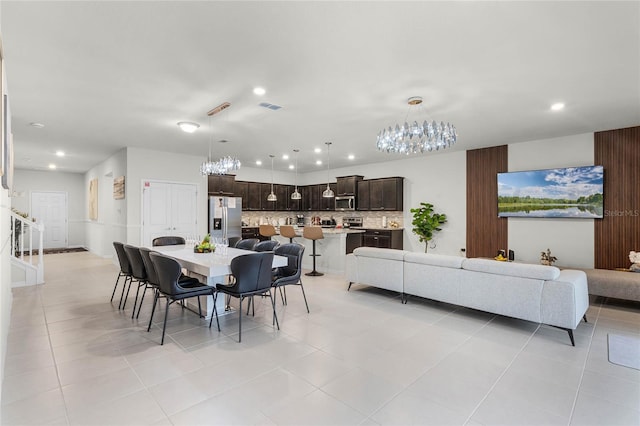 dining space featuring light tile patterned floors, recessed lighting, visible vents, stairway, and an inviting chandelier