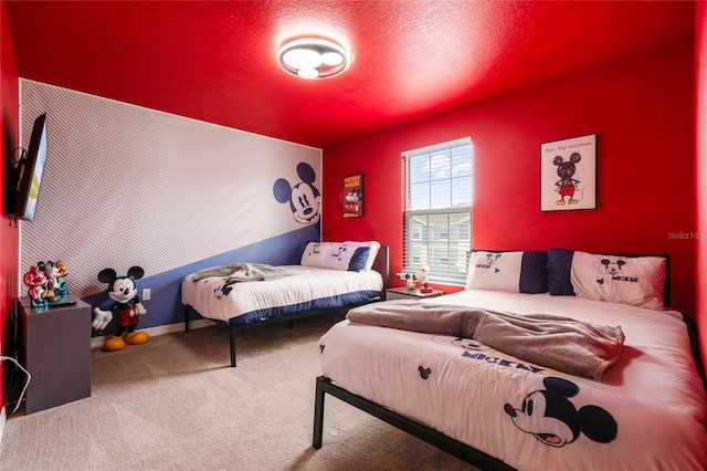 carpeted bedroom featuring a textured ceiling and an accent wall