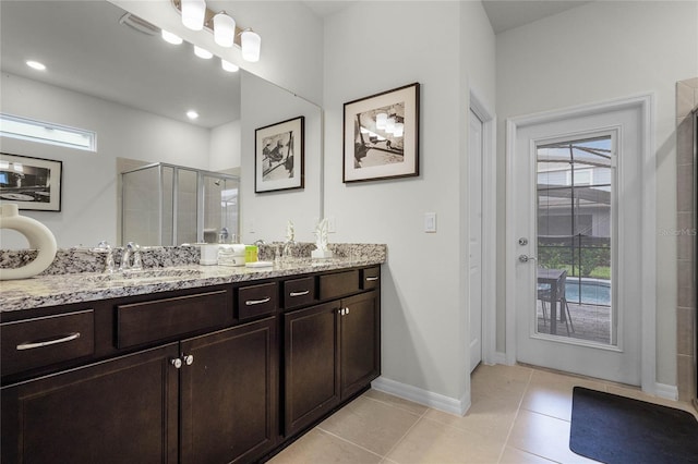 bathroom featuring visible vents, baseboards, vanity, tile patterned floors, and a stall shower