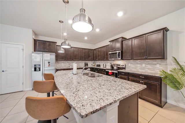 4149 Lana Ave, Davenport, FL 33897 - kitchen featuring appliances with stainless steel finishes, a sink, light tile patterned flooring, dark brown cabinets, and a kitchen bar