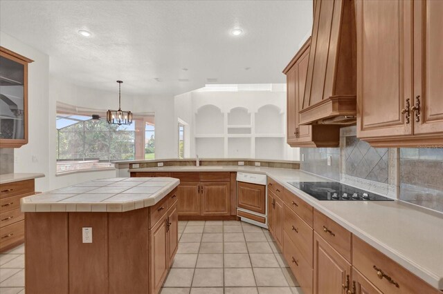 10616 Emerald Chase Dr, Orlando, FL 32836 - kitchen featuring black electric stovetop, tile counters, custom range hood, backsplash, and glass insert cabinets
