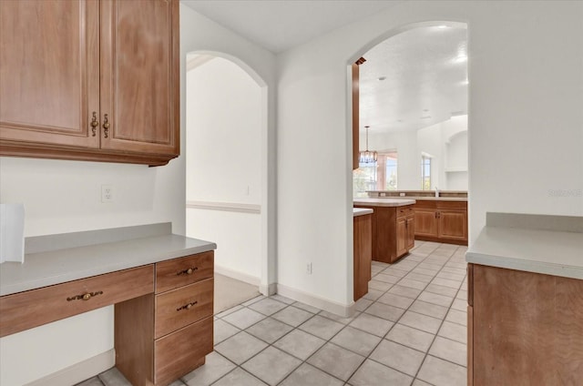 10616 Emerald Chase Dr, Orlando, FL 32836 - kitchen with baseboards, brown cabinets, light countertops, a sink, and light tile patterned flooring
