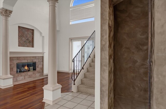 10616 Emerald Chase Dr, Orlando, FL 32836 - staircase with decorative columns, a high ceiling, a fireplace, and wood finished floors