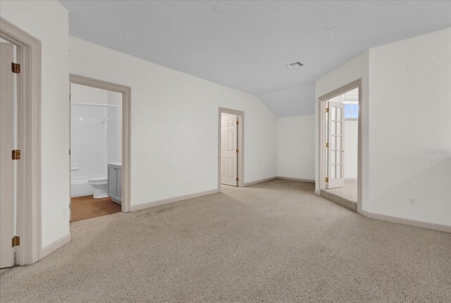10616 Emerald Chase Dr, Orlando, FL 32836 - empty room with lofted ceiling, baseboards, visible vents, and light colored carpet