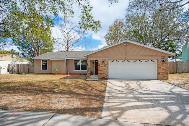 single story home with concrete driveway, an attached garage, fence, a front lawn, and brick siding