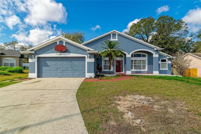 ranch-style house with a front yard, concrete driveway, an attached garage, and stucco siding