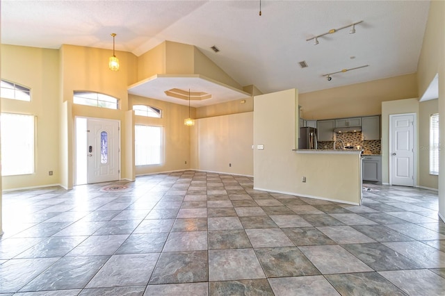 unfurnished living room with high vaulted ceiling, baseboards, and visible vents