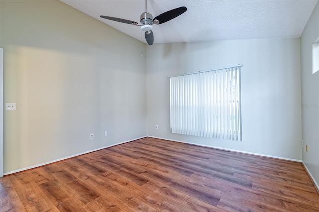 unfurnished room featuring ceiling fan, a healthy amount of sunlight, vaulted ceiling, and wood finished floors