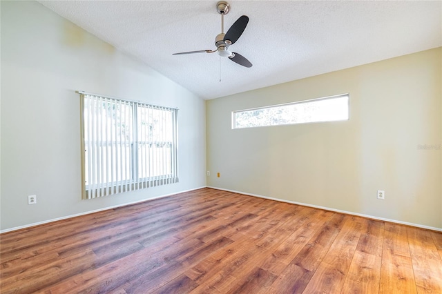 spare room featuring lofted ceiling, ceiling fan, a textured ceiling, and wood finished floors