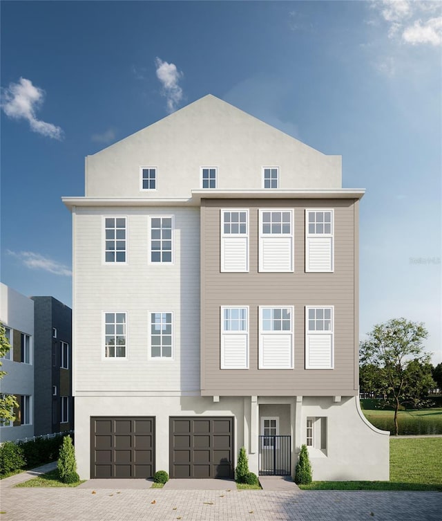 view of front of property featuring decorative driveway, an attached garage, and stucco siding