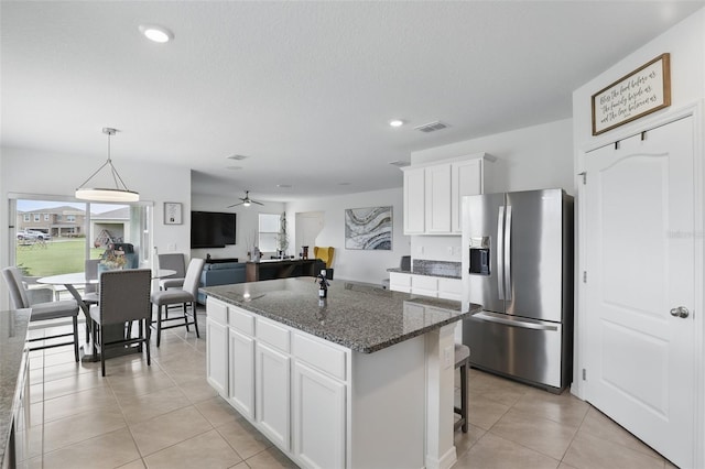 kitchen featuring a center island, visible vents, stainless steel refrigerator with ice dispenser, and light tile patterned floors