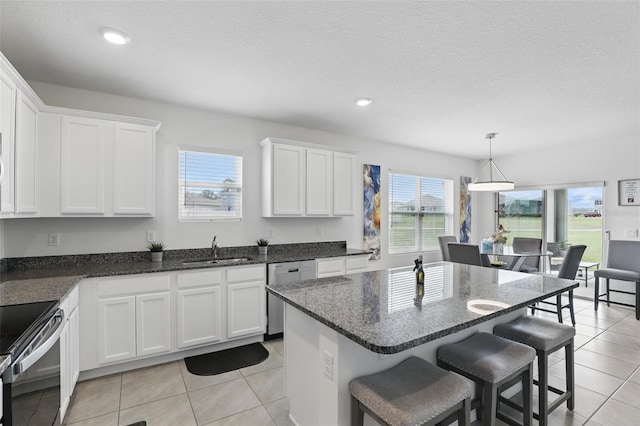 kitchen featuring a sink, a kitchen bar, white cabinetry, and stainless steel dishwasher