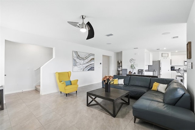 living room featuring stairway, baseboards, visible vents, and a ceiling fan