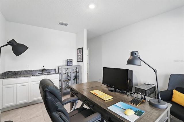 office space with light tile patterned floors, visible vents, and a sink