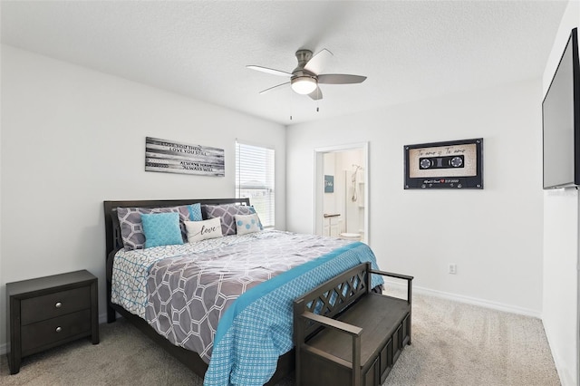 carpeted bedroom with a ceiling fan, ensuite bath, baseboards, and a textured ceiling