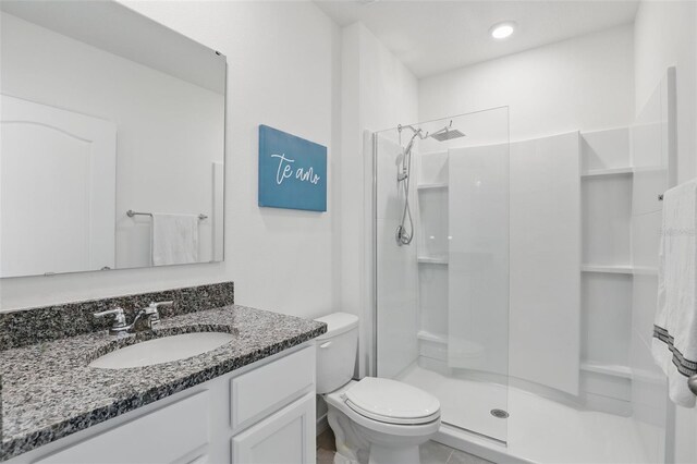 bathroom featuring vanity, toilet, and walk in shower