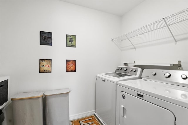 laundry room with laundry area, baseboards, and separate washer and dryer