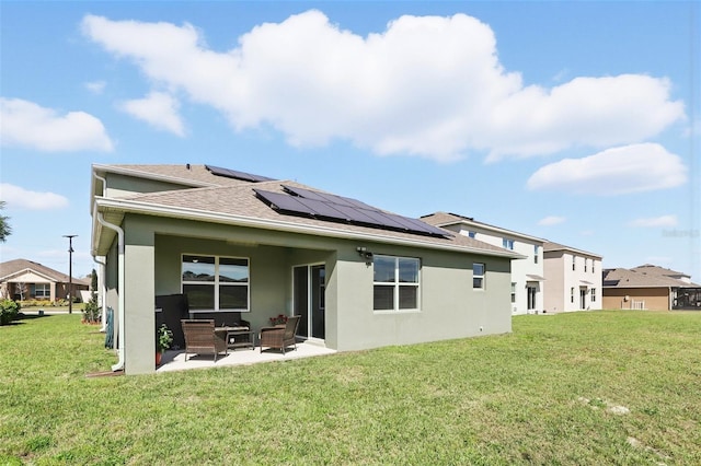 rear view of house featuring solar panels, stucco siding, outdoor lounge area, a lawn, and a patio area