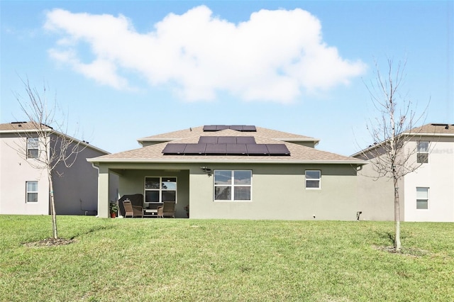 rear view of property with solar panels, a yard, and stucco siding