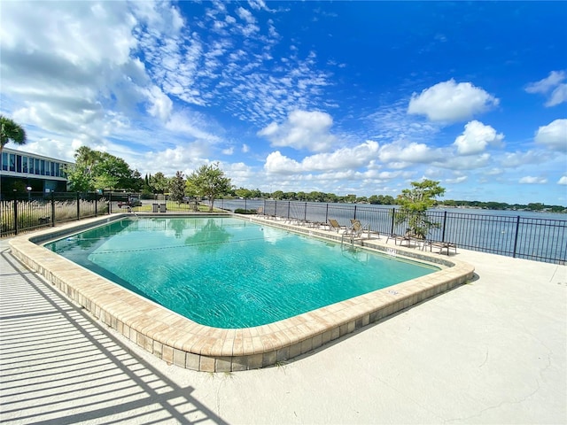 pool with a patio area and fence