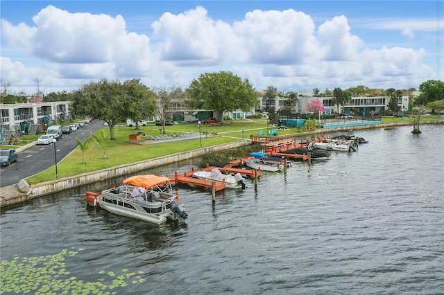 view of dock featuring a water view, a yard, and boat lift