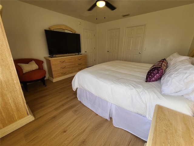 bedroom with visible vents, ceiling fan, and wood finished floors