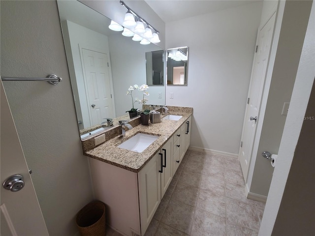 bathroom featuring double vanity, a sink, and baseboards