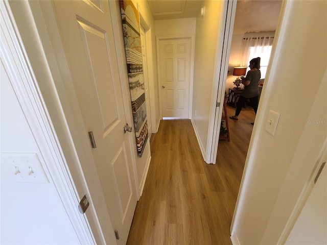 hall with light wood finished floors and baseboards