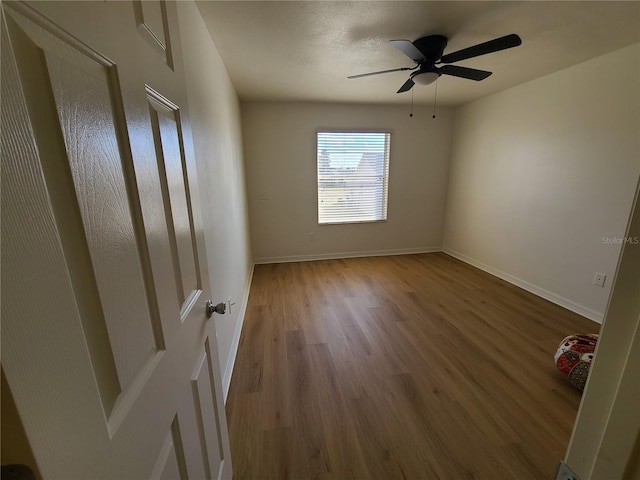 unfurnished bedroom with ceiling fan, baseboards, and wood finished floors