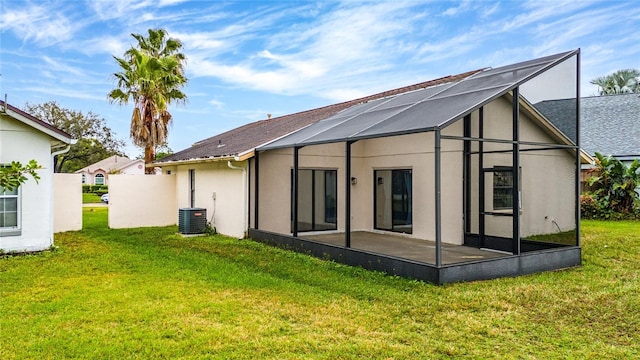 back of property featuring a yard, central AC unit, a lanai, and stucco siding