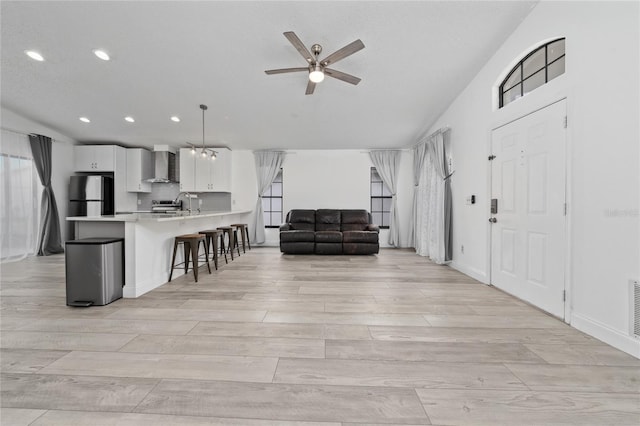 interior space with recessed lighting, visible vents, light wood-style floors, ceiling fan, and baseboards