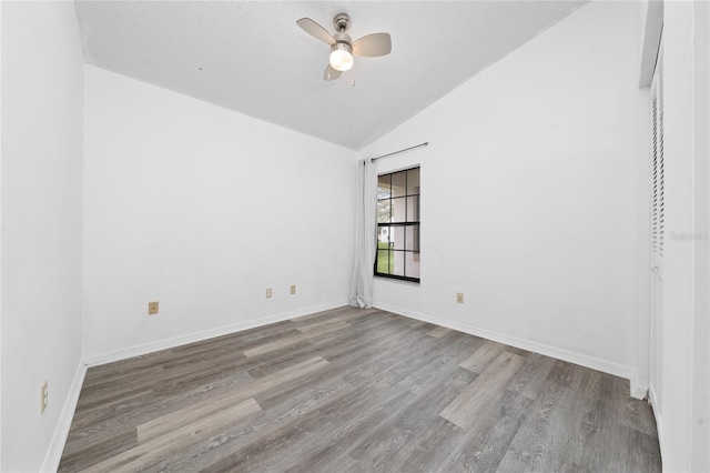 unfurnished room featuring vaulted ceiling, ceiling fan, baseboards, and light wood-style floors