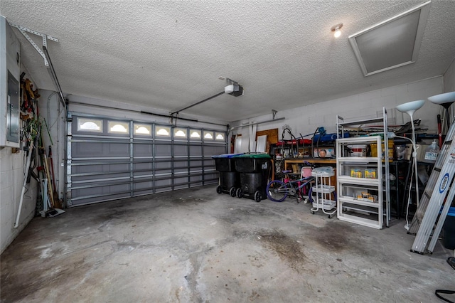 garage featuring concrete block wall and a garage door opener