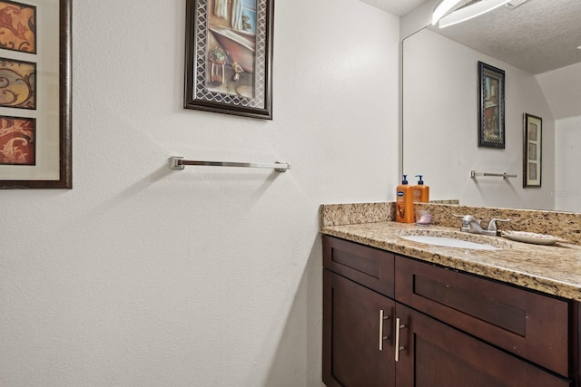 bathroom with a textured ceiling and vanity