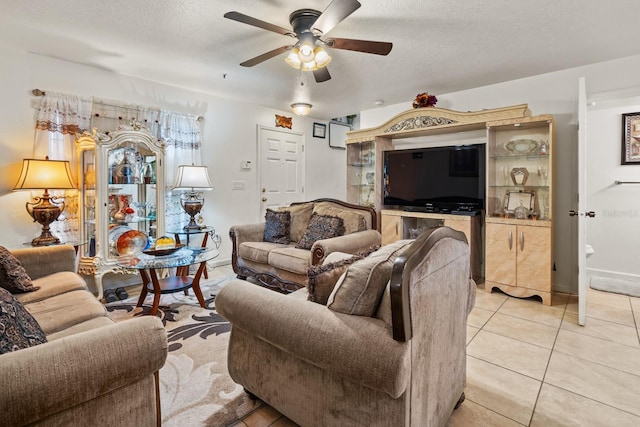 living area featuring a textured ceiling, light tile patterned flooring, and a ceiling fan