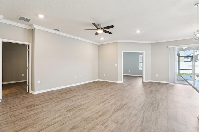 empty room featuring crown molding, visible vents, and wood finished floors