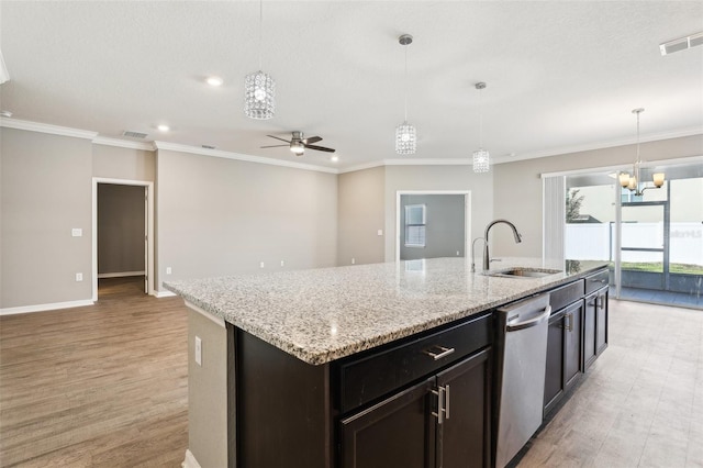 kitchen featuring a kitchen island with sink, a sink, visible vents, hanging light fixtures, and ornamental molding