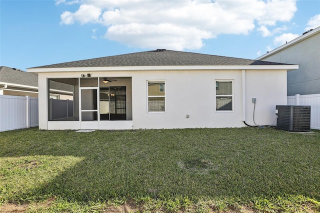 back of house featuring central air condition unit, a sunroom, fence, and a yard