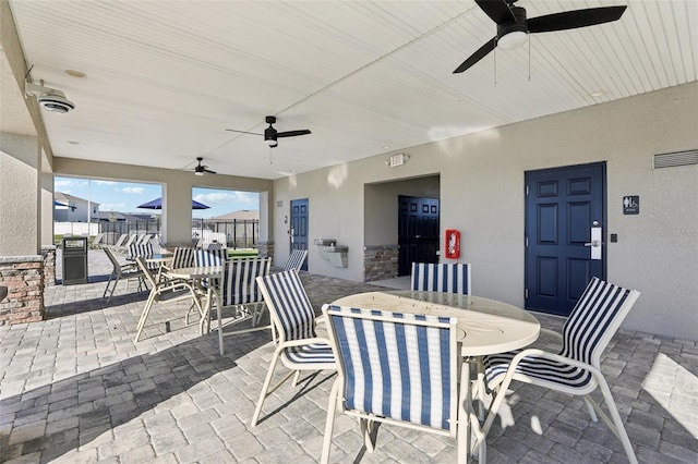 view of patio featuring a ceiling fan, outdoor dining space, and fence