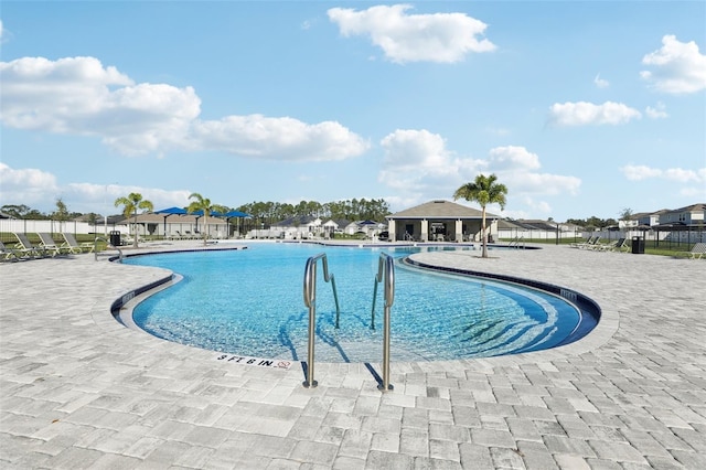 community pool with fence and a patio