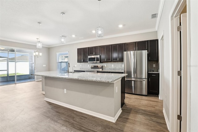 411 Lily Ln, Davenport, FL 33837 - kitchen featuring stainless steel appliances, backsplash, a chandelier, wood finished floors, and ornamental molding