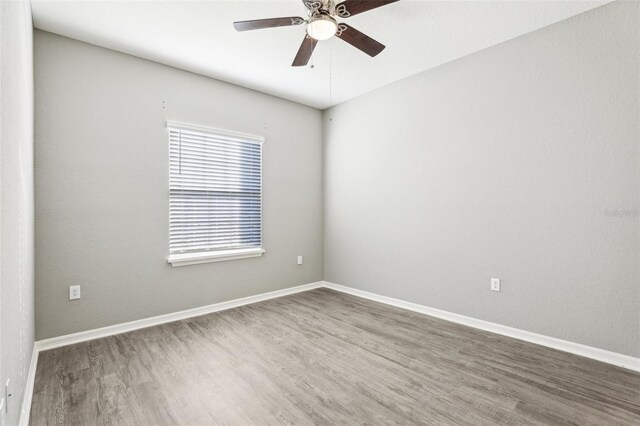 411 Lily Ln, Davenport, FL 33837 - empty room with wood finished floors and a ceiling fan