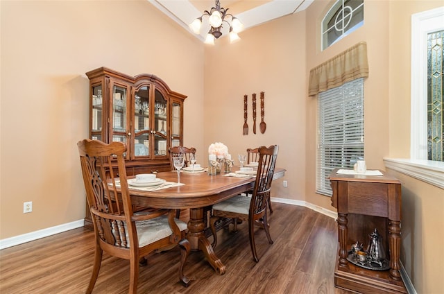 dining space featuring an inviting chandelier, wood finished floors, and baseboards