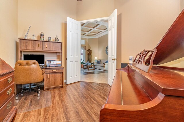 home office featuring coffered ceiling, wood finished floors, and beam ceiling