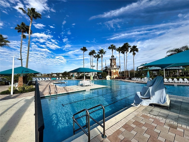 pool with a water slide and a patio