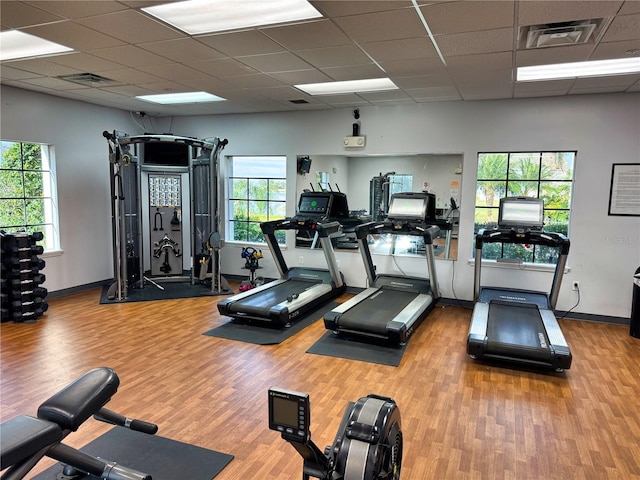 gym featuring a paneled ceiling, visible vents, and wood finished floors