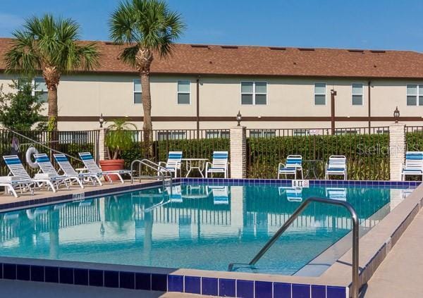 view of swimming pool featuring fence