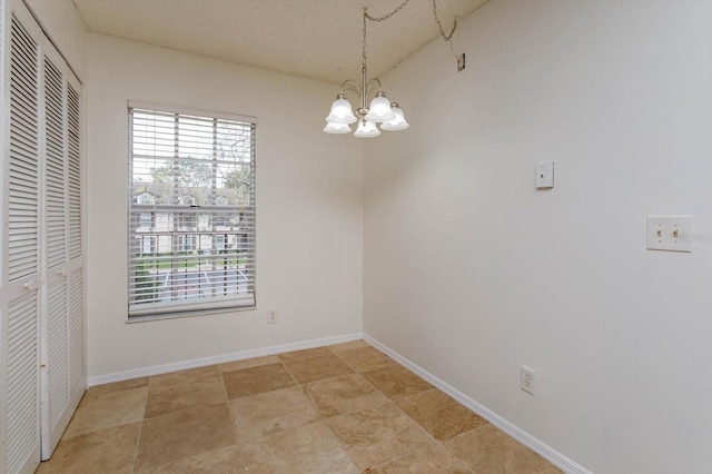 unfurnished dining area with baseboards and a notable chandelier